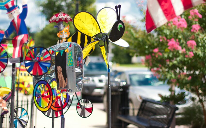 Closeup of yard decor, including a glass bee and spinners