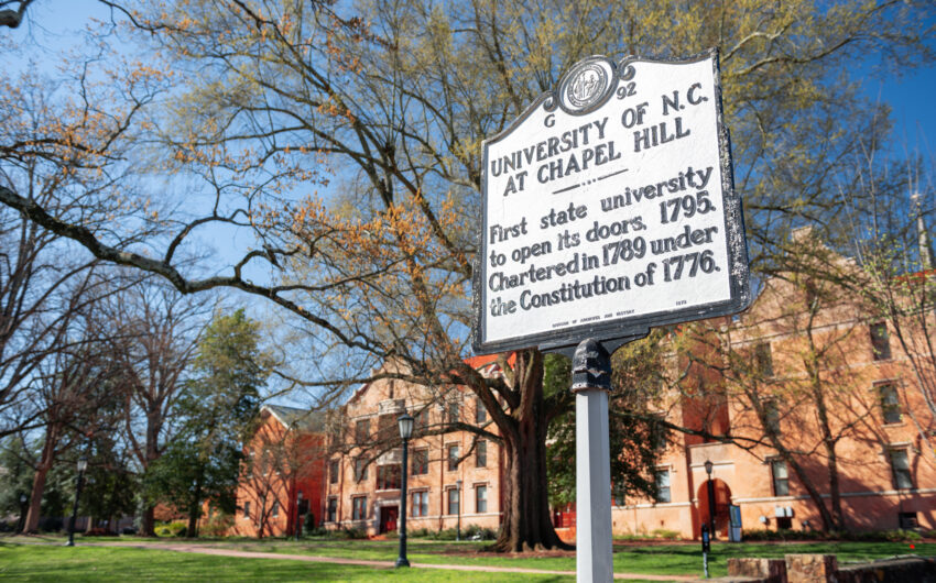 UNC Chapel HIll campus and sign claiming “the first state university to open its doors.”