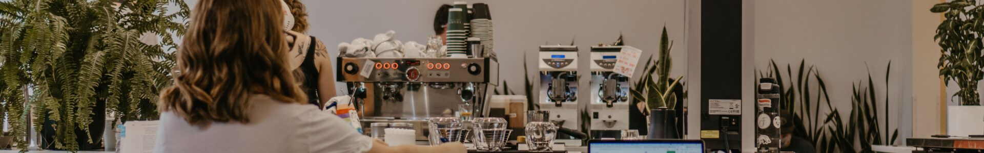 A female barista at the counter in a modern coffee shop