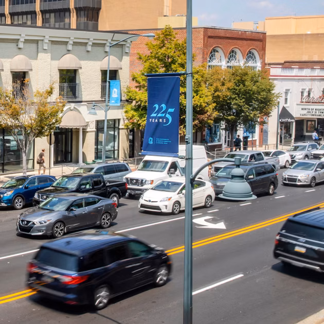 cars driving a downtown street in one direction