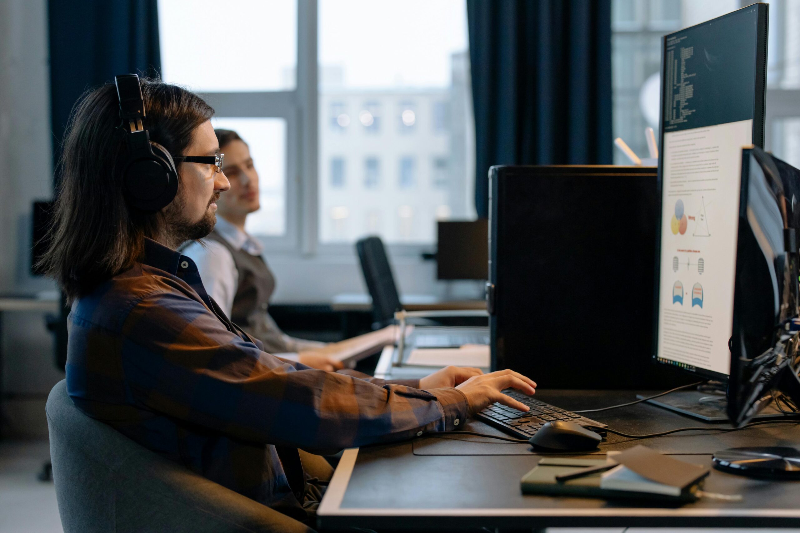 Two programmers working together with focus on coding in a modern, tech-savvy office environment.